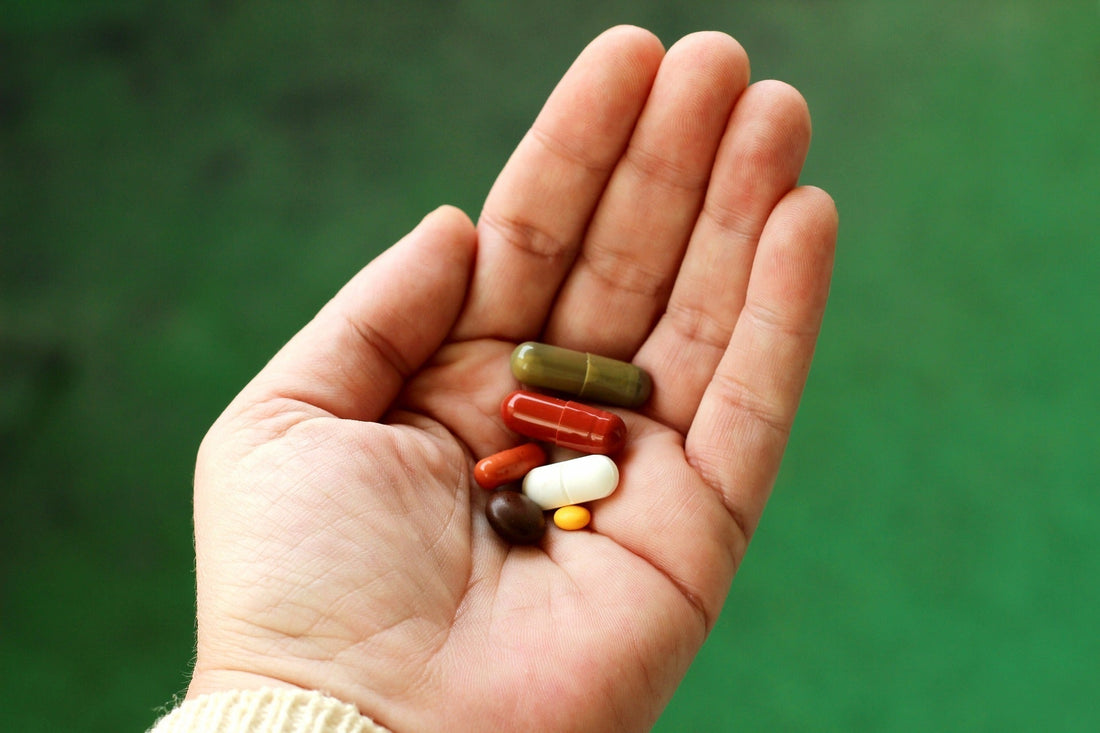 Hand met verschillende capsules en pillen voor mensen met moeite met pillen slikken
